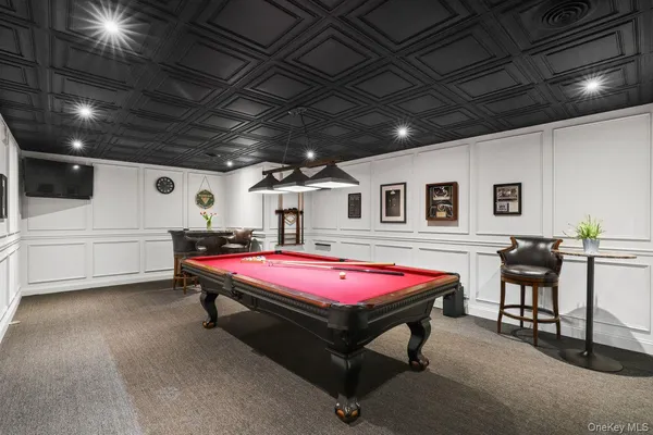 a room with furniture pool table and window