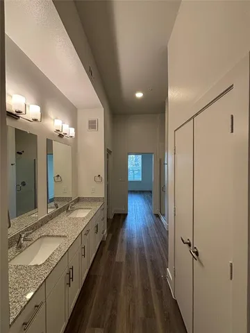a spacious bathroom with a granite countertop sink mirror and a shower