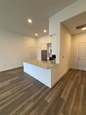 a view of kitchen with granite countertop cabinets and wooden floor