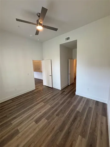 a view of a livingroom with wooden floor and a ceiling fan