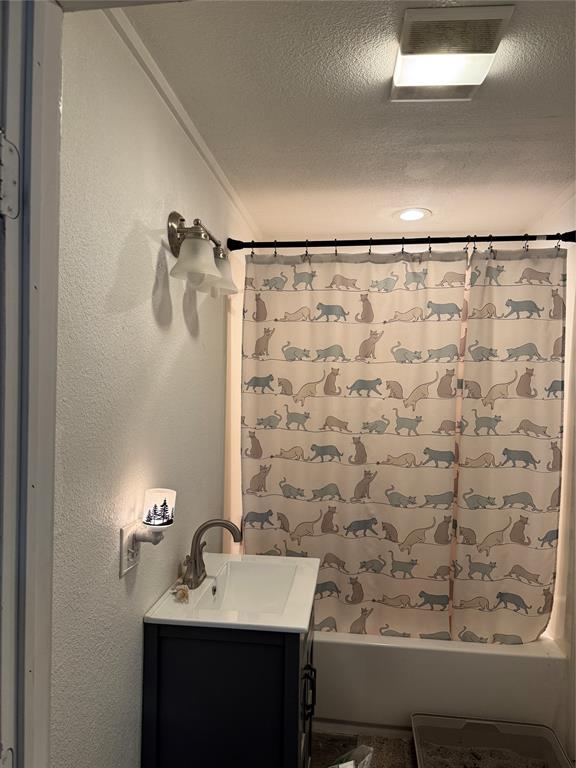 2300 Lyle Avenue Waco, TX 76708 - Photo 20 of 23 Full bath with vanity, a textured ceiling, shower / bath combo, a textured wall, and crown molding