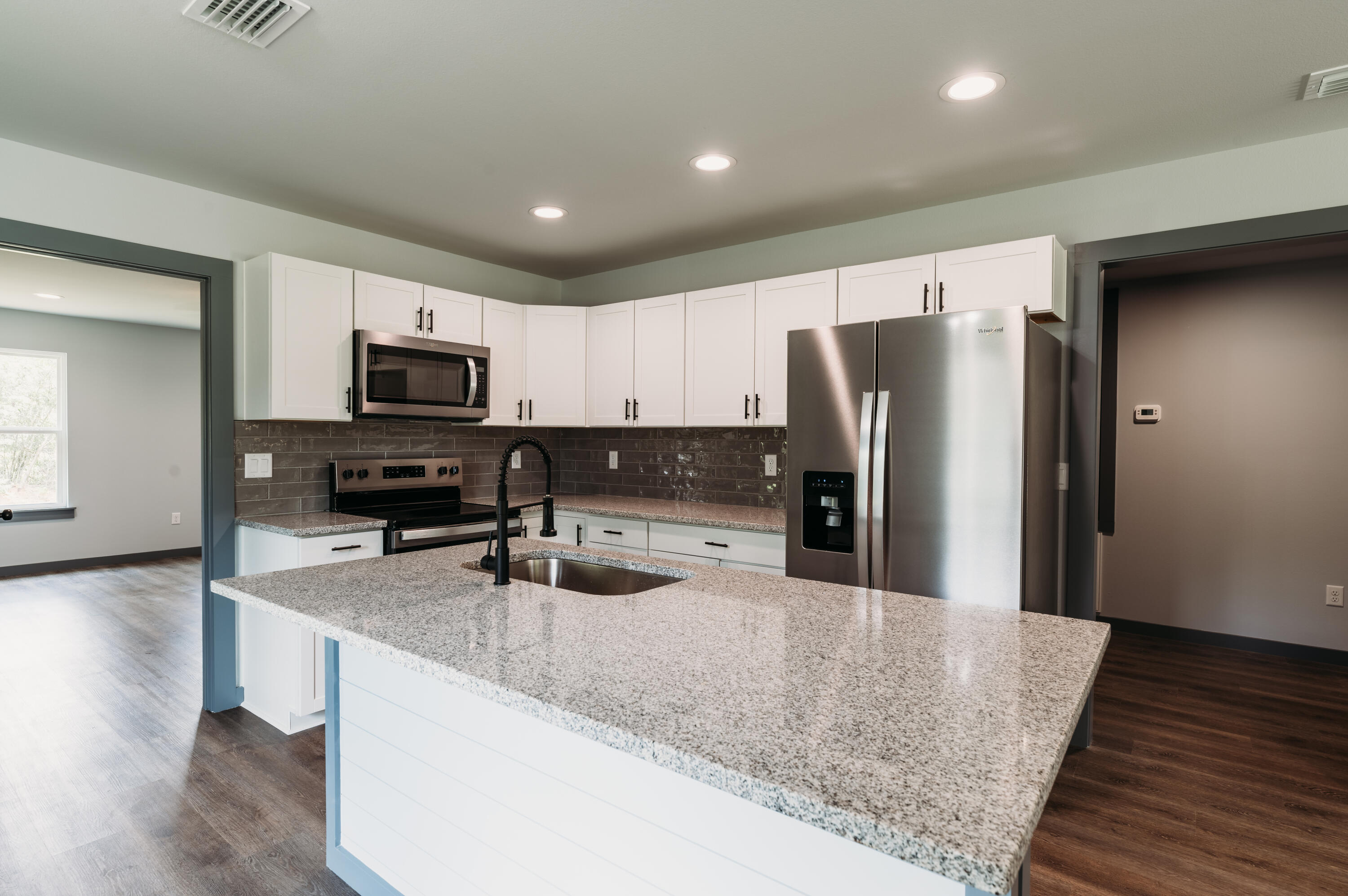 4618 Eagle Way Crestview, FL 32539 - Photo 4 of 12 a kitchen with stainless steel appliances granite countertop a refrigerator a stove a sink and a microwave