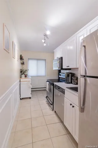 a kitchen with stainless steel appliances a refrigerator sink and microwave