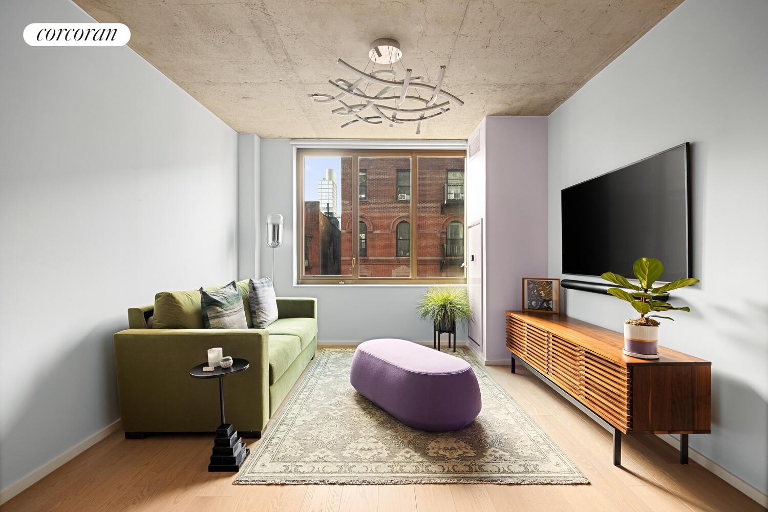 196 Orchard Street, Unit 5K Manhattan, NY 10002 - Photo 2 of 8 a living room with furniture a flat screen tv and a large window