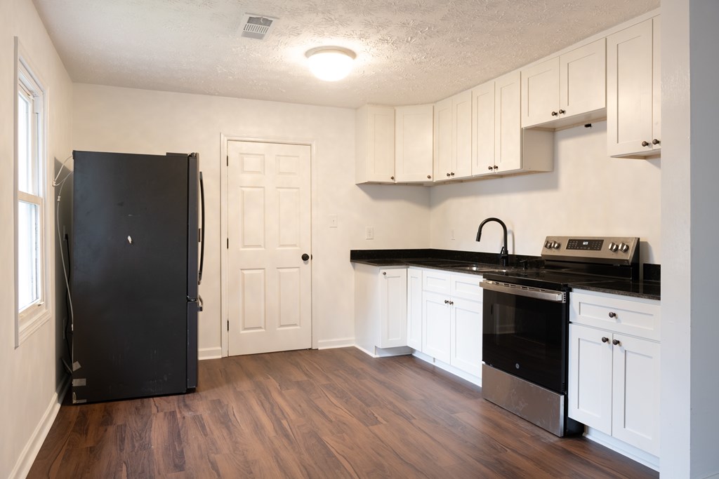 3946 Forestside Drive Columbus, GA 31907 - Photo 2 of 20 a kitchen with granite countertop white cabinets and black appliances