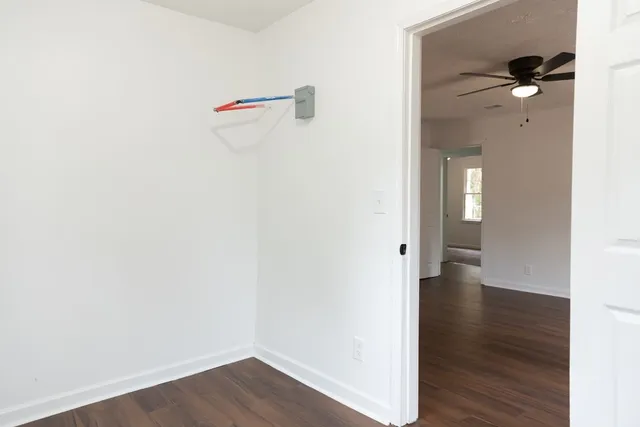 a view of a hallway with wooden floor and closet