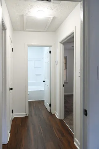 an empty room with wooden floor & closet area