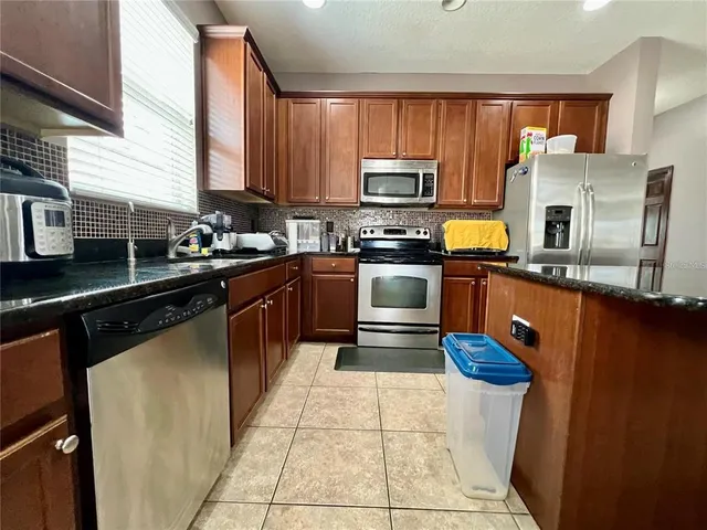 a kitchen with stainless steel appliances a sink stove refrigerator and microwave