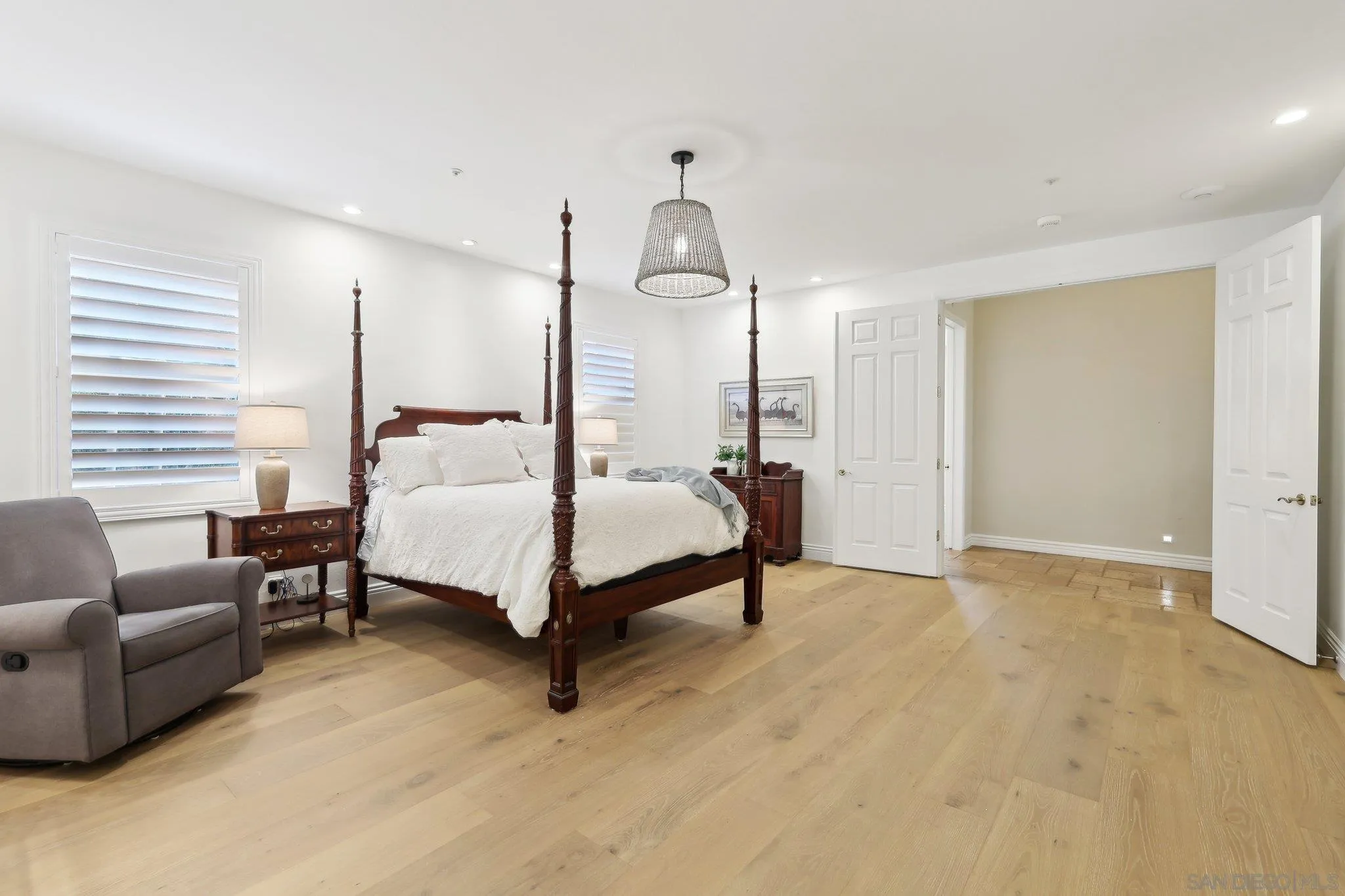 17702 Old Winery Way Poway, CA 92064 - Photo 31 of 75 a spacious bedroom with a bed a couch and a chandelier