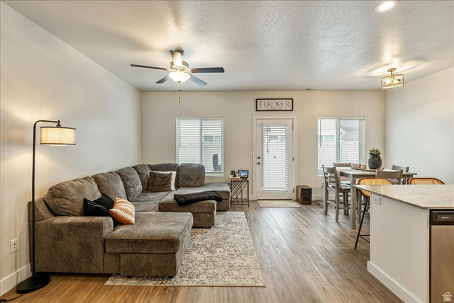 287 North 100th West Morgan, UT 84050 - Photo 6 of 27 Living area featuring a textured ceiling, light wood finished floors, a ceiling fan, and healthy amount of natural light