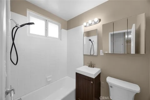 a bathroom with a granite countertop sink a toilet and a mirror