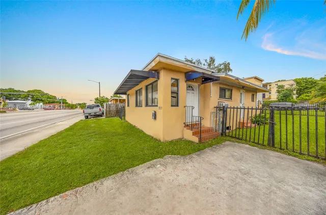 a view of a house with a yard and pathway