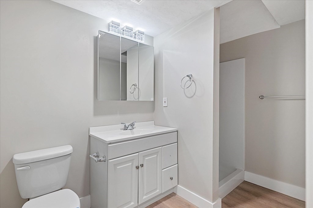 74 Hill Road, Unit B Charlton, MA 01507 - Photo 19 of 23 a bathroom with a toilet sink vanity and mirror
