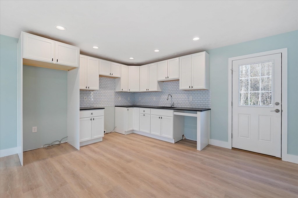 74 Hill Road, Unit B Charlton, MA 01507 - Photo 3 of 23 a large kitchen with stainless steel appliances granite countertop a stove a sink and a refrigerator with wooden floors