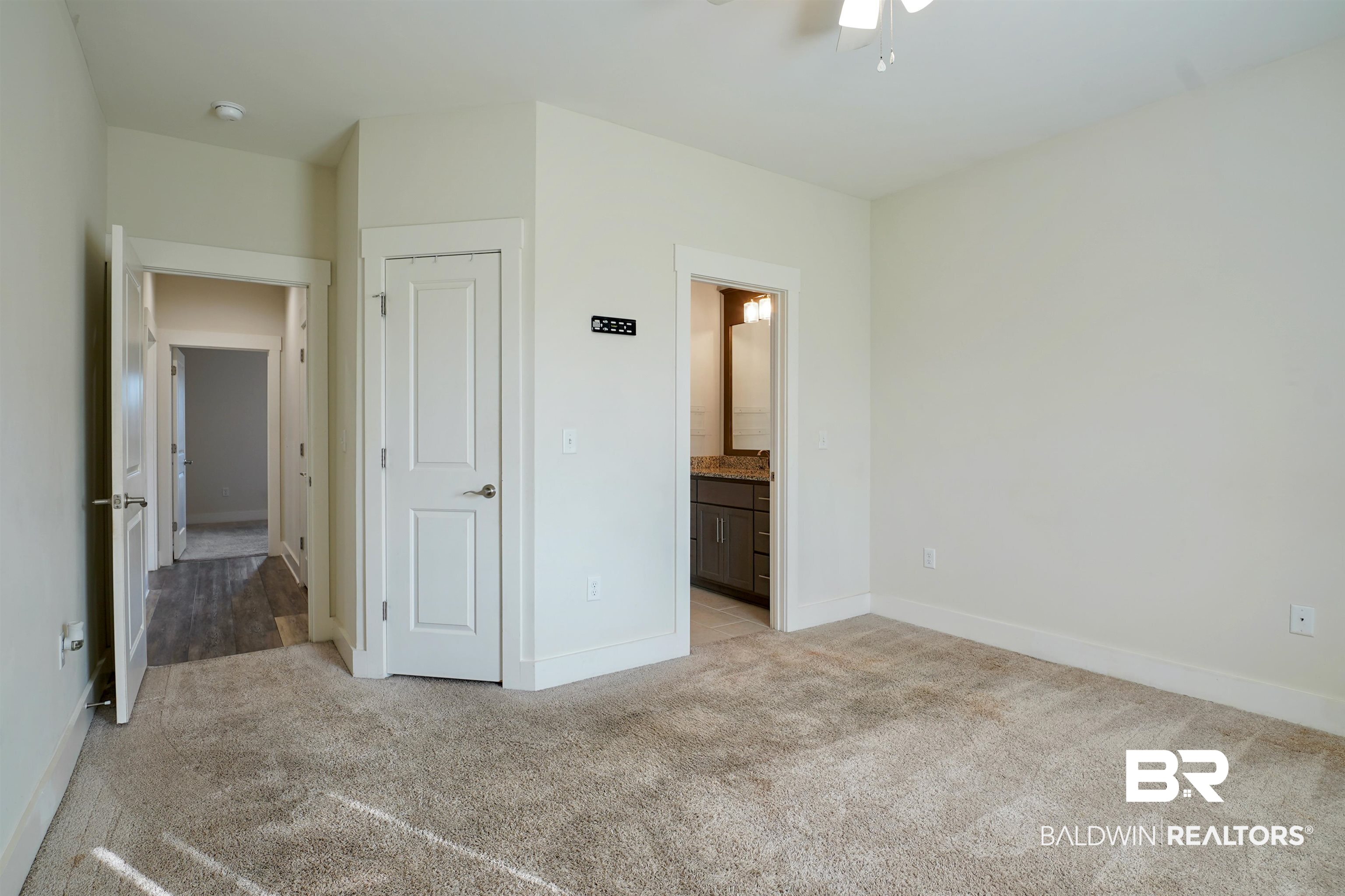 7090 Rocky Rd Loop Gulf Shores, AL 36542 - Photo 22 of 34 Unfurnished bedroom with light colored carpet, ensuite bath, and baseboards