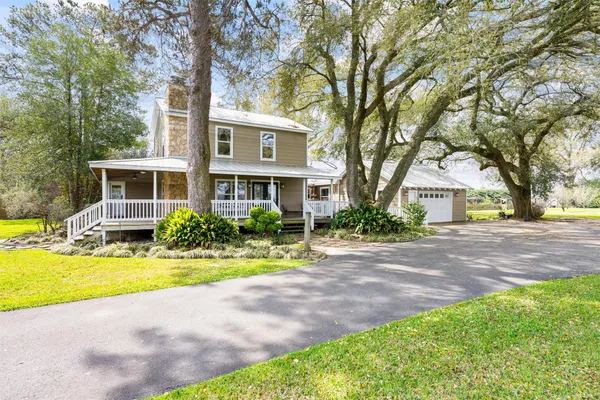 an aerial view of a residential houses with outdoor space and a lake view