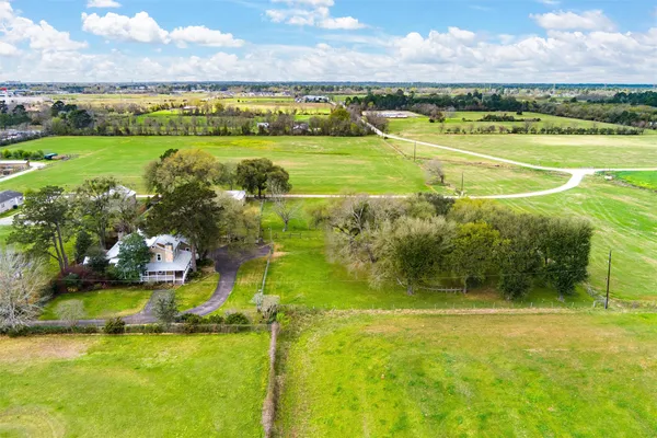 a view of a house with a yard and potted plants