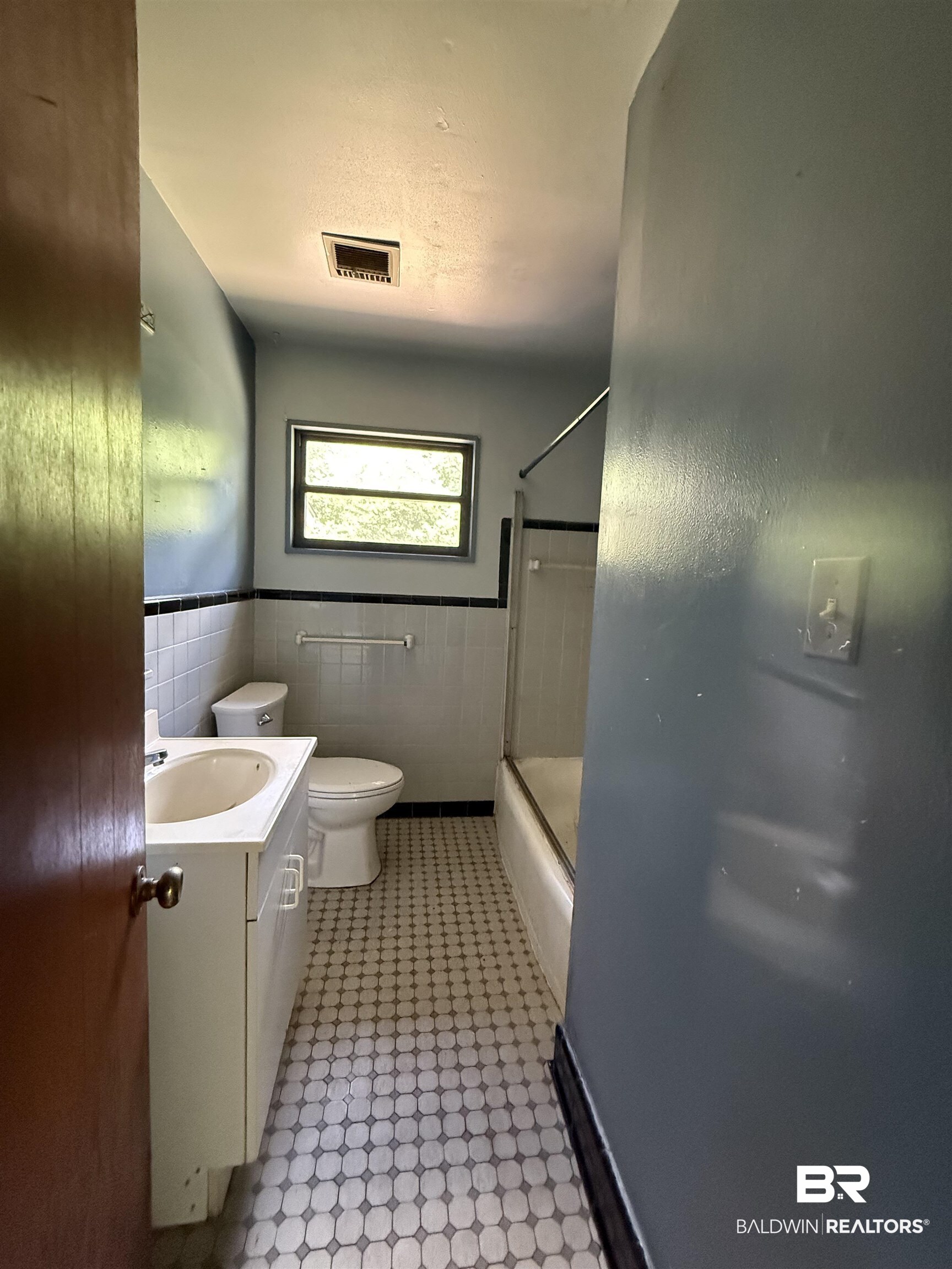711 Wilshire Road Mobile, AL 36609 - Photo 9 of 11 Bathroom featuring a white vanity with integrated sink, toilet, and a bathtub with shower enclosure