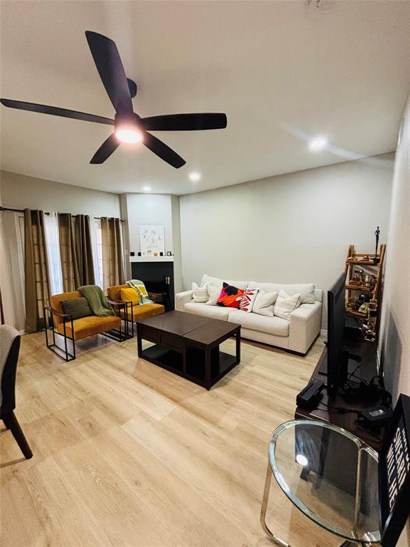 14277 Preston Road, Unit 416 Dallas, TX 75254 - Photo 8 of 40 Wood-finish flooring, recessed lighting, ceiling fan with integrated light, and a built-in fireplace with a dark mantel