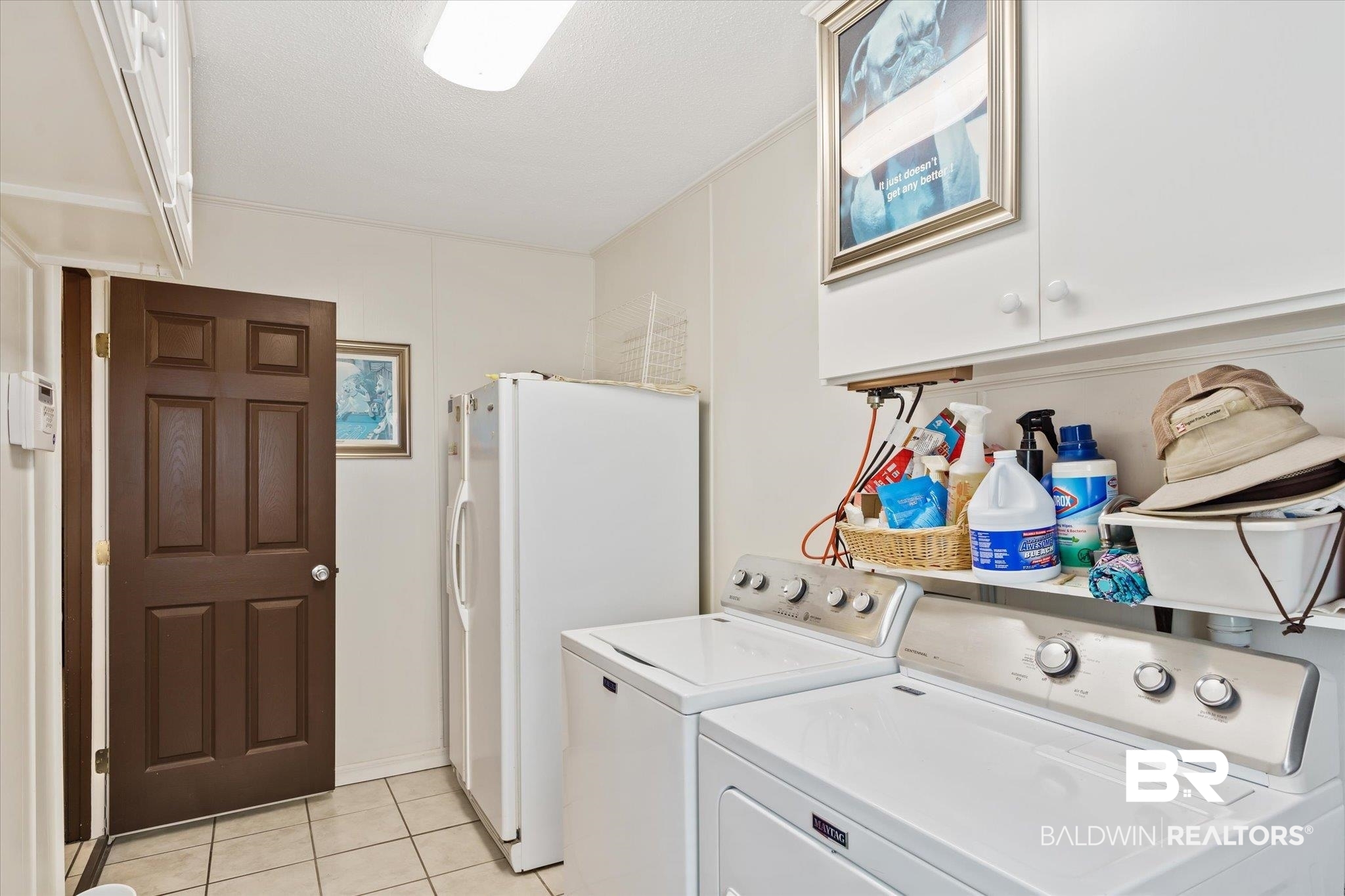 1604 Celeste Road Saraland, AL 36571 - Photo 20 of 31 Laundry area with crown molding, cabinets, washer and clothes dryer, and light tile patterned flooring