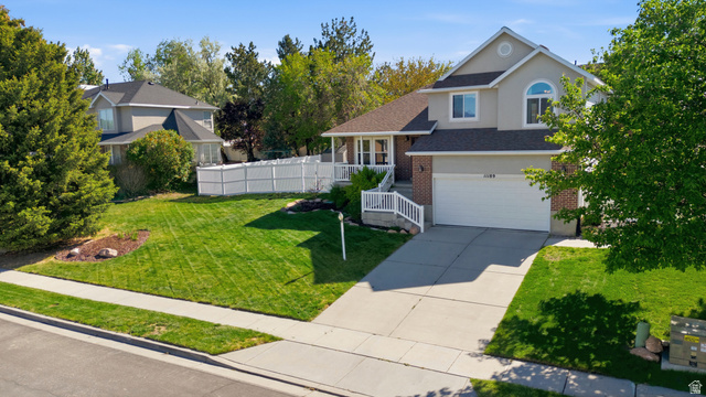 11189 Ohenry Road East Sandy, UT 84070 - Photo 42 of 44 Two-story residence featuring a gray exterior with brick accents and a prominent front-facing garage
