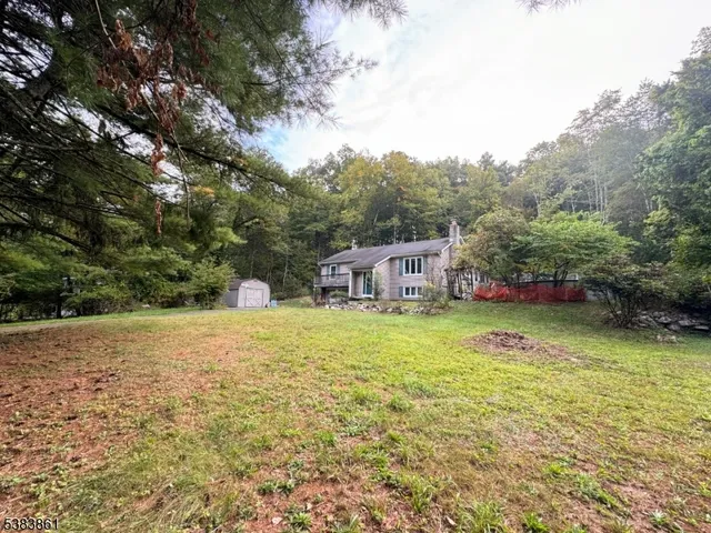 a view of a house with a yard and sitting area