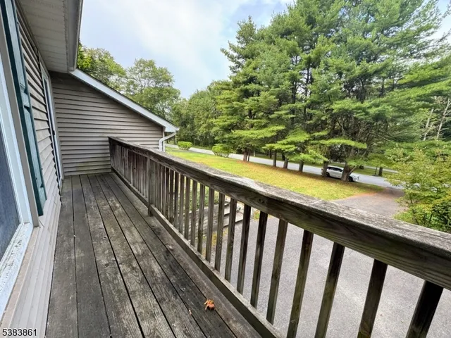 an empty room with a chandelier fan and windows