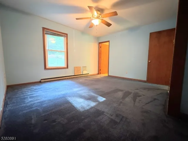 a view of room with window ceiling fan and hardwood floor