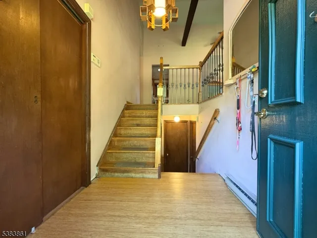a view of staircase with lots of frames on wall and wooden floor