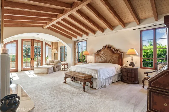 a spacious bedroom with a bed and a large window