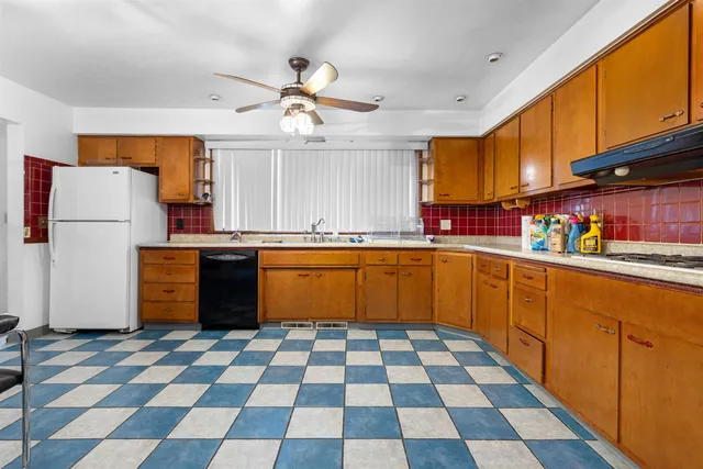 a kitchen with a cabinets a sink and white appliances