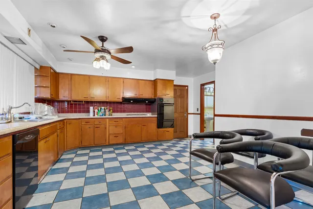 a living room with a black white checkered floor with a gaming machine and dining table