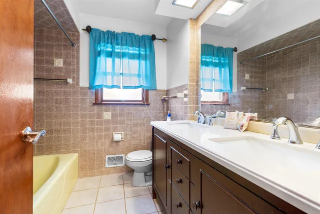 a bathroom with a granite countertop sink a toilet and mirror