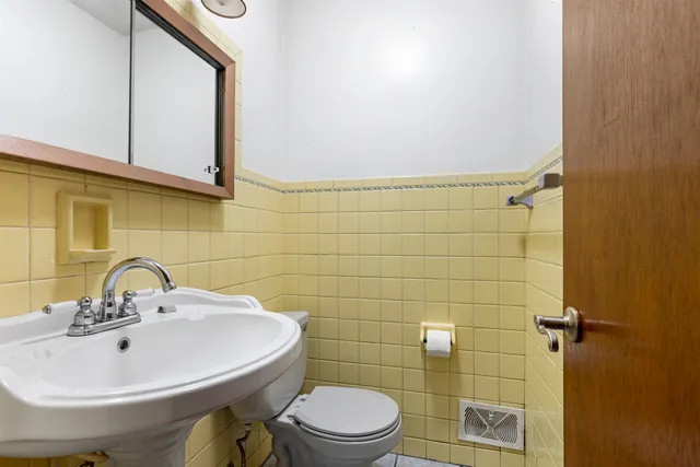 a bathroom with a sink a toilet and mirror