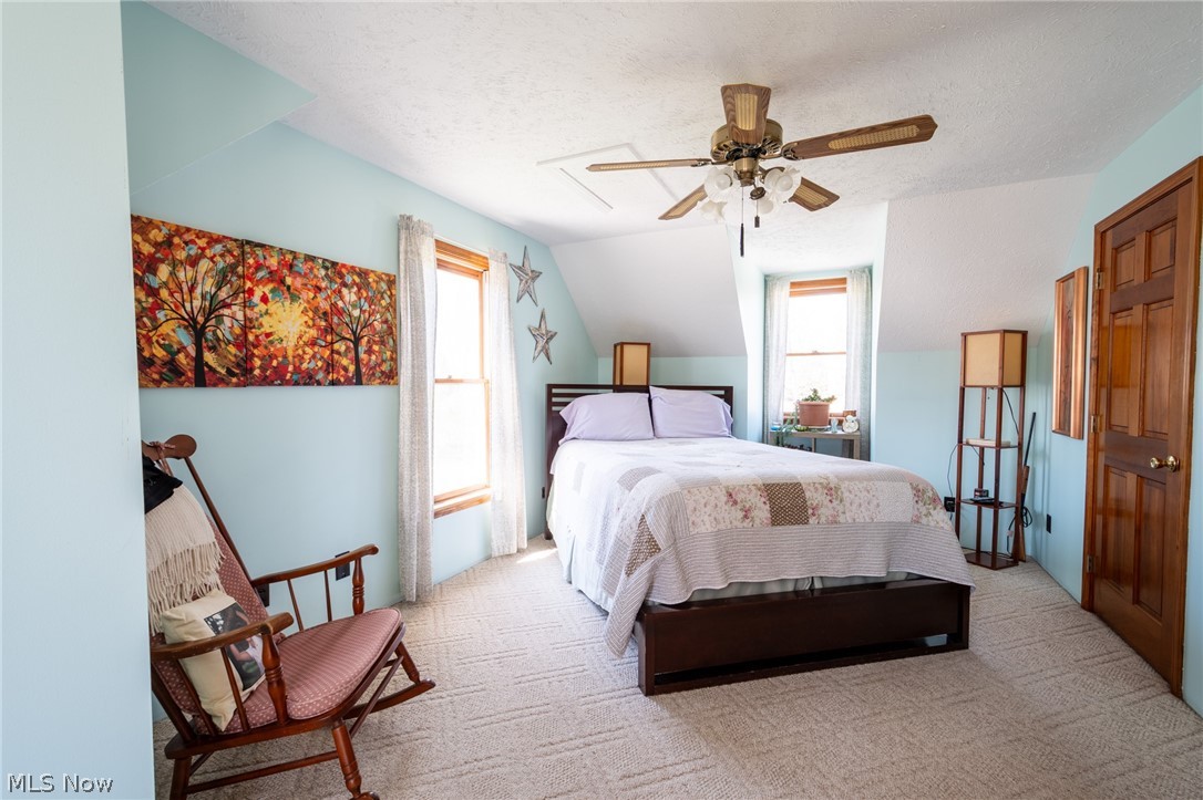 14027 Mayfield Road Huntsburg, OH 44046 - Photo 21 of 50 Bedroom with light blue walls, sloped ceilings, and patterned carpeting