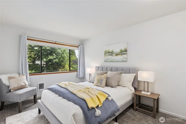 a bedroom with a bed and a large window