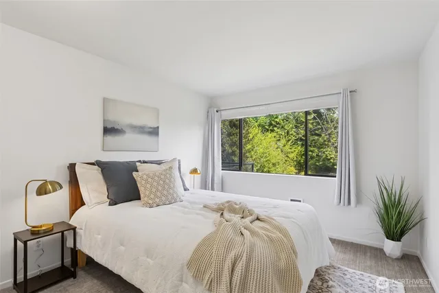 a bedroom with a bed and a large window