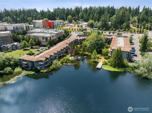 a view of a lake with a house swimming pool and outdoor seating