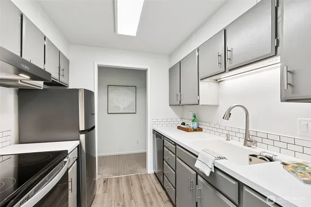 a kitchen with stainless steel appliances a sink stove and refrigerator