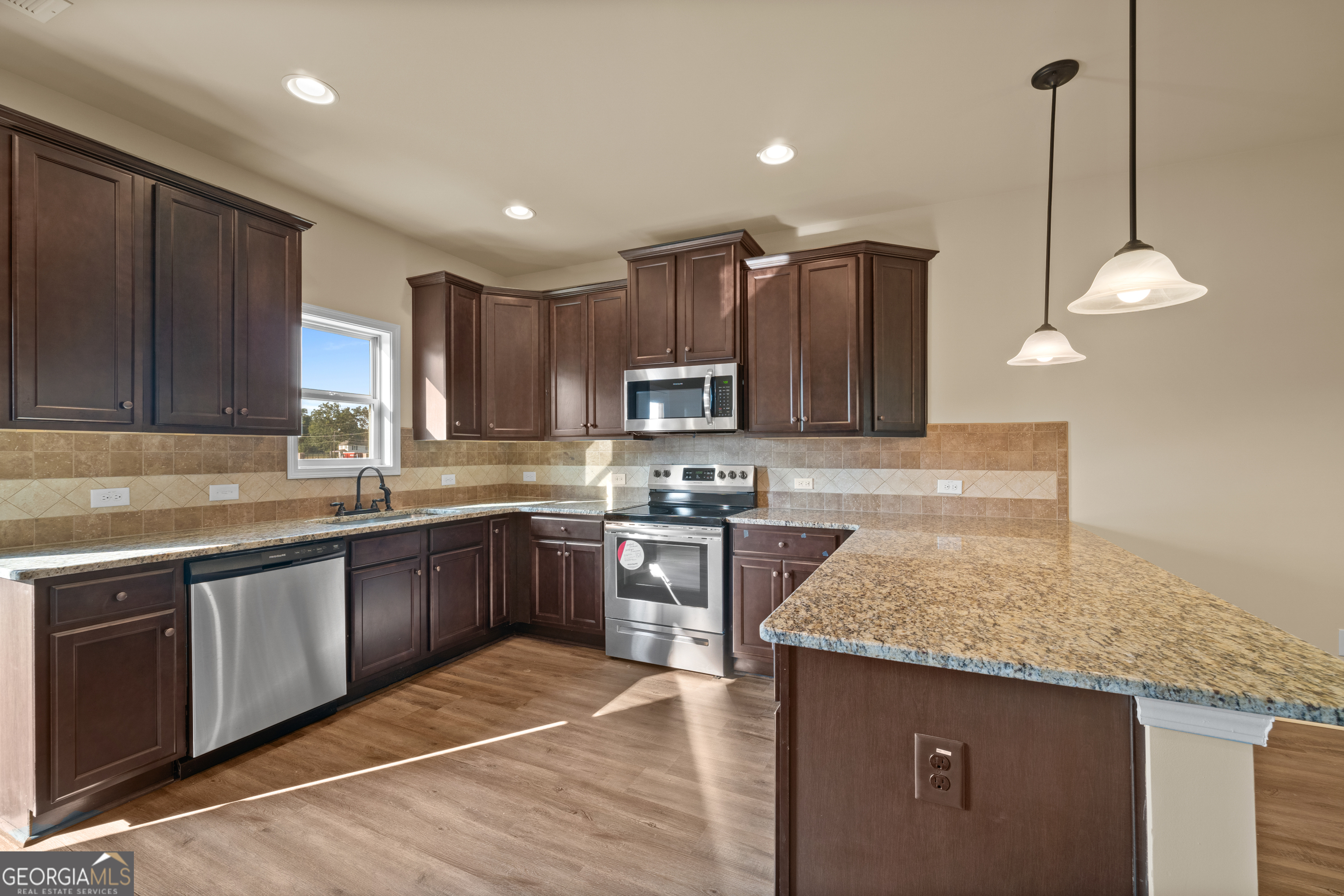 2381 Aukerman Trace, Unit 81 Hampton, GA 30228 - Photo 7 of 17 a kitchen with stainless steel appliances granite countertop a sink a stove and a wooden floors