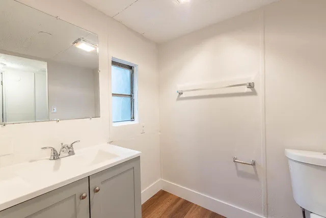 a bathroom with a sink a toilet and a mirror