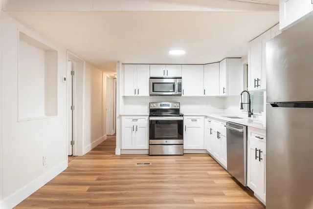 a kitchen with granite countertop a refrigerator stove and sink