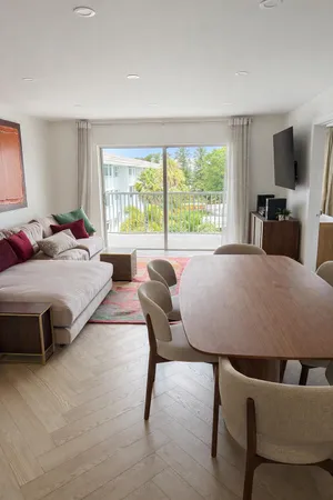 a living room with furniture a rug and white walls