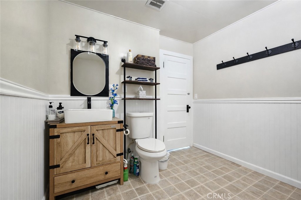 633 East Walnut Street Willows, CA 95988 - Photo 12 of 21 a bathroom with a toilet a sink and mirror