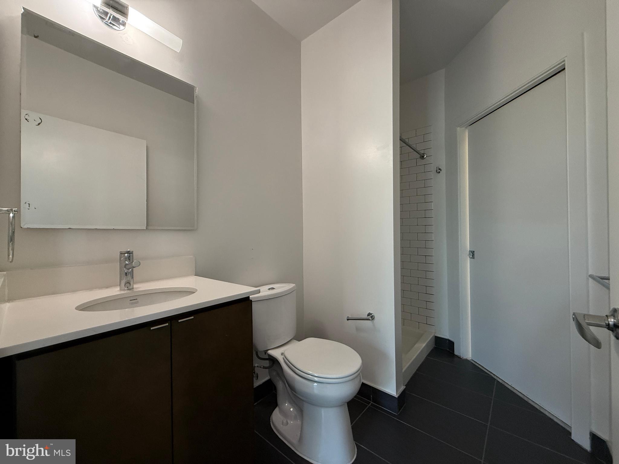 1250 9th Street Northwest, Unit 411 Washington, DC 20001 - Photo 14 of 22 a bathroom with a toilet a sink and mirror
