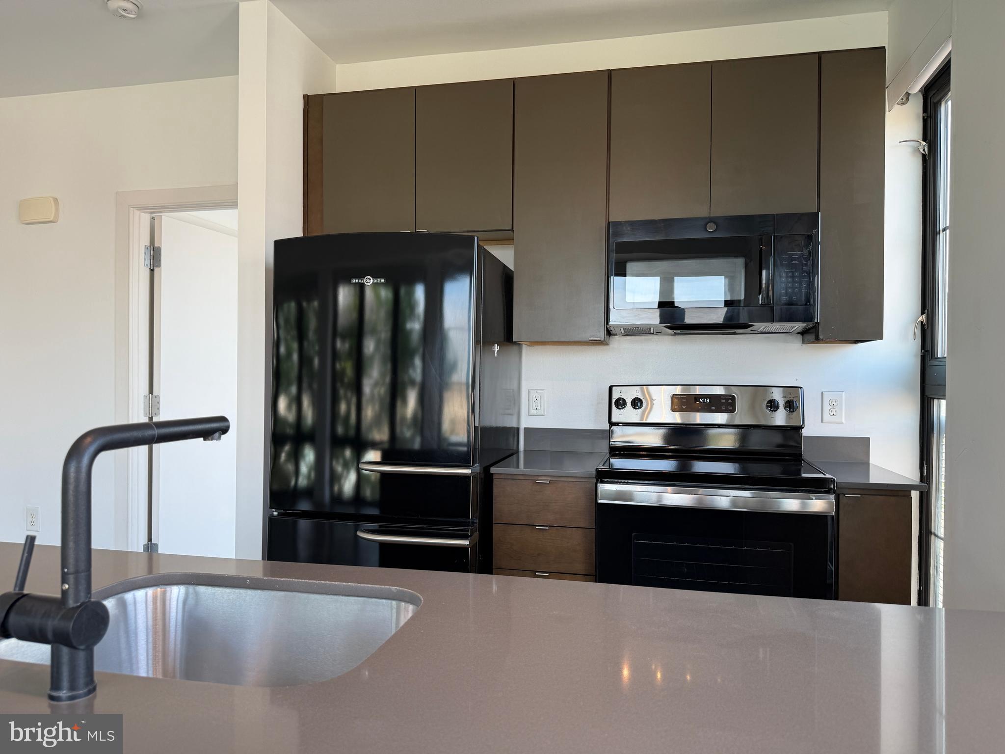 1250 9th Street Northwest, Unit 411 Washington, DC 20001 - Photo 8 of 22 a kitchen with granite countertop a stove and a refrigerator