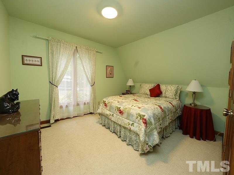 8600 Valley Brook Drive Raleigh, NC 27613 - Photo 10 of 25 a bedroom with a bed and a chandelier