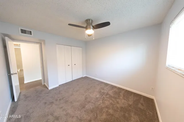 an empty room with closet and windows