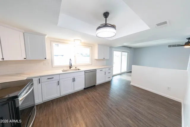 a large kitchen with a wooden floor and stainless steel appliances