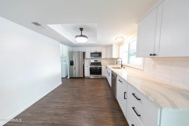 a large kitchen with cabinets and stainless steel appliances